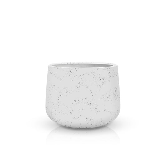The Aura di Pietra Planter - Medium by Landmark Decor is a speckled ceramic planter with a rounded base on a reflective surface, offering a blend of luxury and nature, set against a plain white backdrop.