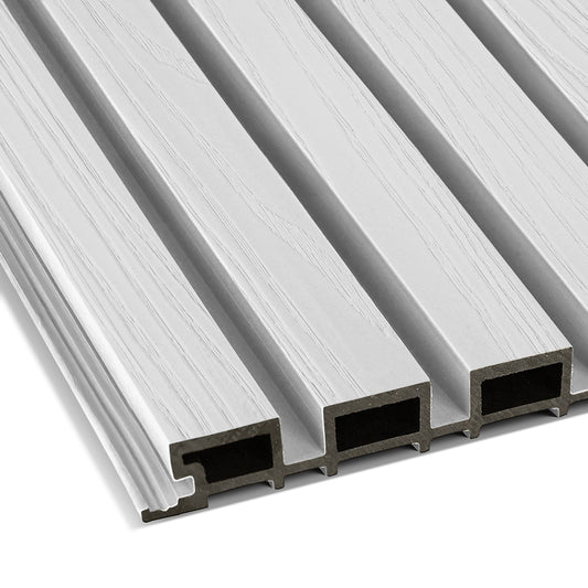 Close-up of four Arctic Frost Exterior WPC Panels by Landmark Decor—light gray, wood-grain textured rectangles with ridged edges and hollow interiors, arranged side by side—perfect for outdoor wall decoration.