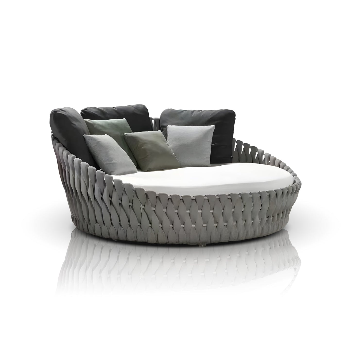 The Mediterranea Luxe Lounge by Landmark Decor is a round woven outdoor chair with a gray braided base, cushioned seat, and multiple back pillows in gray and green, set against a reflective white surface for an ideal luxurious outdoor experience.