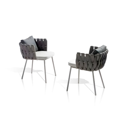 Landmark Decors Coastal Woven Collection offers two modern chairs with black woven backrests and armrests, ideal for alfresco dining. Each weather-resistant chair includes a white cushion seat and a gray pillow, set against a plain white backdrop.