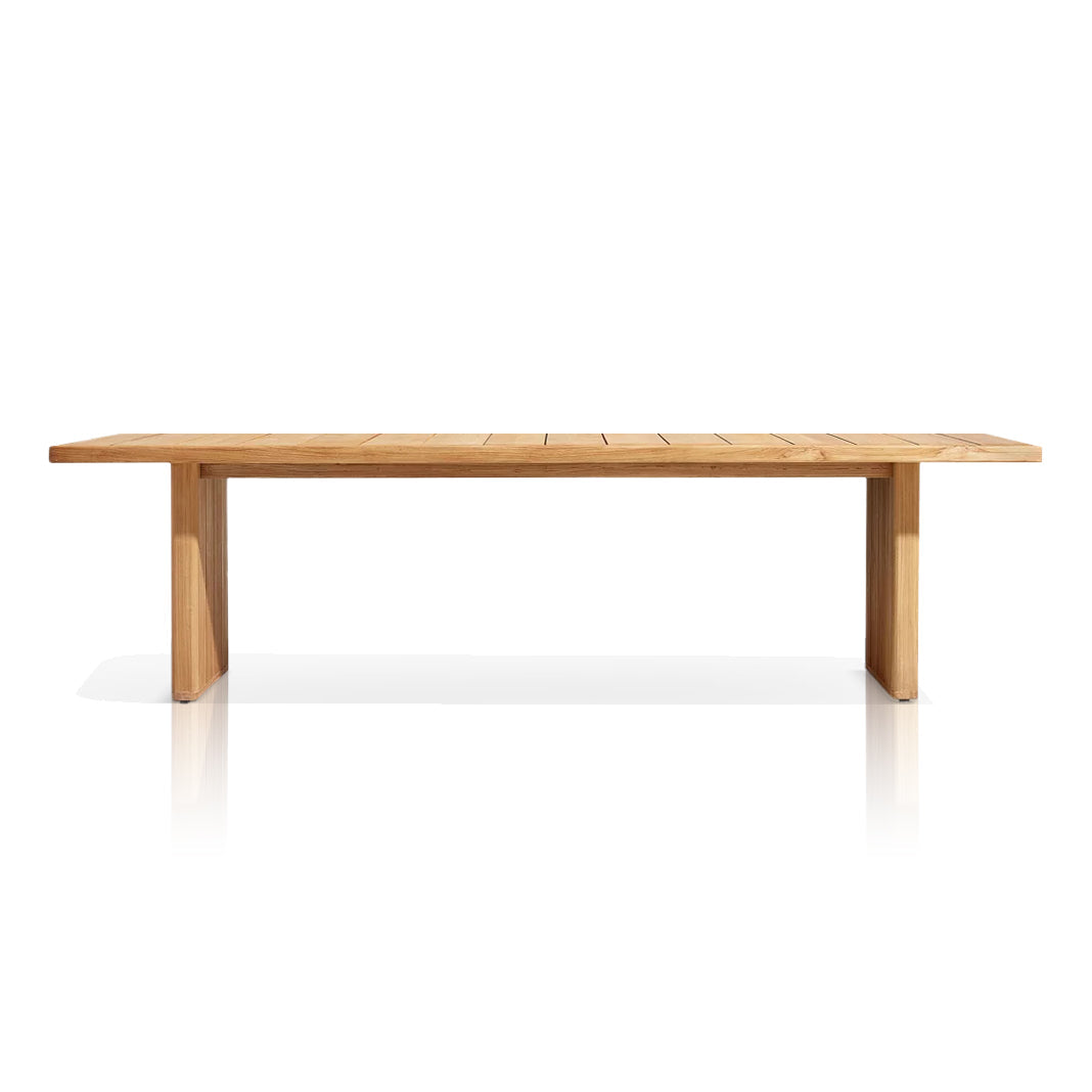 The Sienna Terrace Collection by Landmark Decor features a long, rectangular wooden table with a smooth surface and simple design. It has two sturdy legs on each end and is crafted for alfresco dining, boasting a light wood finish against a plain white background.