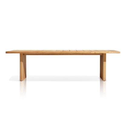 The Sienna Terrace Collection by Landmark Decor features a long, rectangular wooden table with a smooth surface and simple design. It has two sturdy legs on each end and is crafted for alfresco dining, boasting a light wood finish against a plain white background.