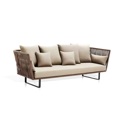 The Sierra Luxe Collection by Landmark Decor is a modern outdoor sofa with a sleek design, featuring weather-resistant beige cushions, four matching pillows, and a woven backrest. Its minimalist metal frame boasts all-weather durability and rattan-like armrests on a pristine white backdrop.