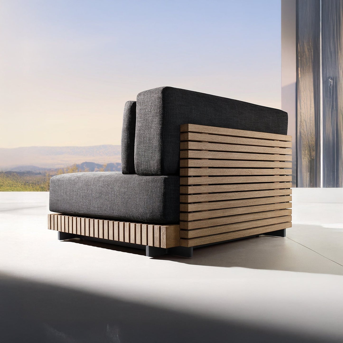 The Palazzo Tranquillo Collection by Landmark Decor features a modern chair with weather-resistant cushions and a wooden slatted frame. Positioned in a minimalist space with large windows, it offers views of mountains and blue sky, creating a serene ambiance.