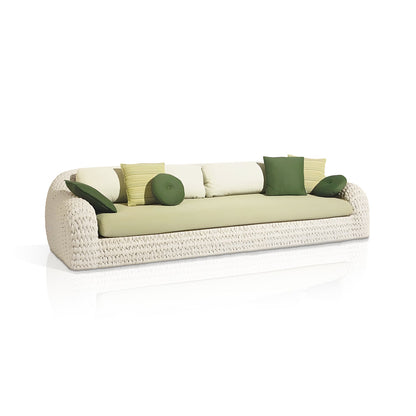 The Marbella Retreat Collection by Landmark Decor showcases a woven rattan outdoor sofa with light green cushions and assorted green and white pillows, artfully arranged. Designed for durability, it features an all-weather frame set against a plain white backdrop.