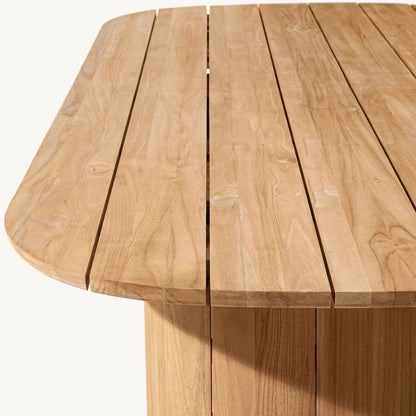 A close-up of a Timber Serenity Collection table by Landmark Decor, designed for alfresco dining, highlights its smooth light brown wood grain and clean lines. Parallel slats across the surface showcase its natural texture, while weather-resistant materials promise durability in any setting.