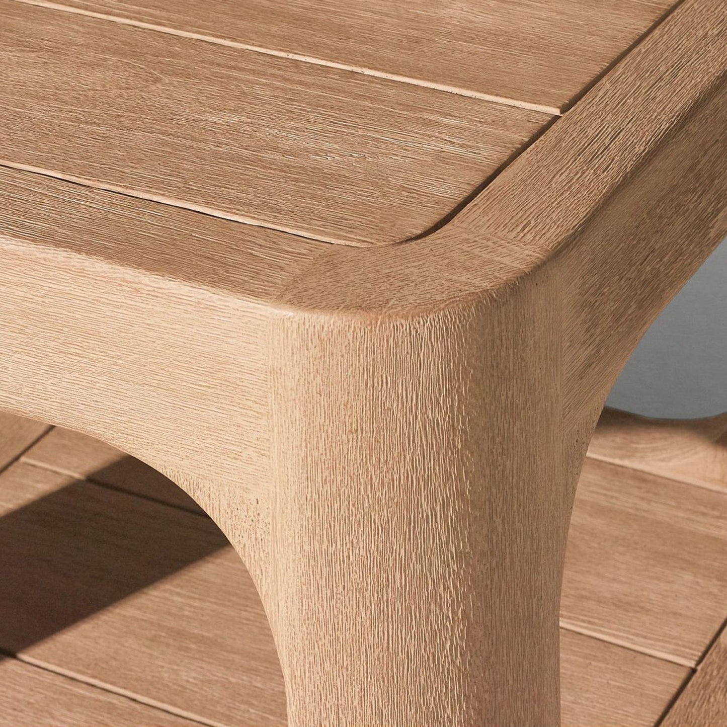 The Bali Luxe Retreat Set by Landmark Decor showcases a wooden table corner with smooth edges and natural grain, perfect for outdoor living. Its light brown finish and rustic charm are enhanced by an additional premium wooden shelf below the tabletop.