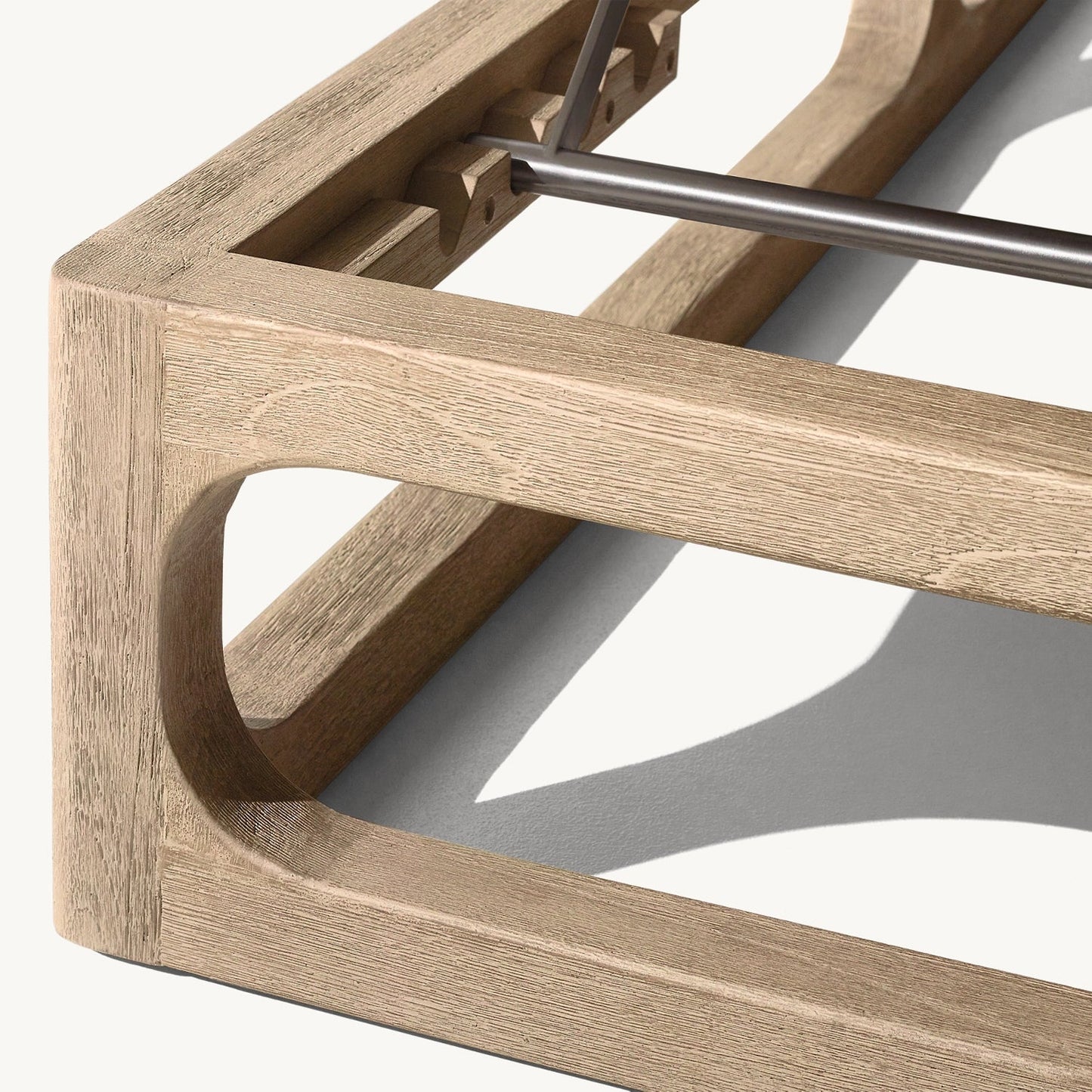 Close-up of the Bali Luxe Retreat Set by Landmark Decor, a minimalist wooden bed frame crafted from premium materials. The light-colored wood features a smooth finish and a top metal support bar. Its sleek design evokes the easy elegance of outdoor living as its shadow dances below.