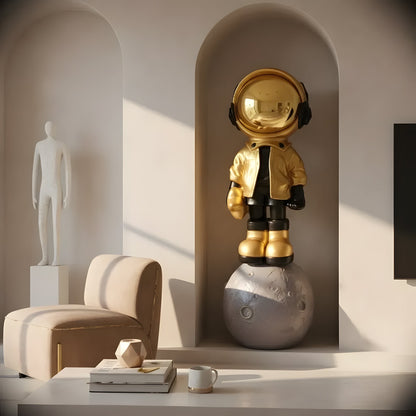 The Astronaut of the Stars by Landmark Decor features a gold-helmeted figurine on a moon sculpture, adding artistic flair to a modern, neutral-toned living room with minimalist style.