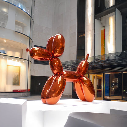The Landmark Decor Balloon Dog is a large, shiny orange metallic sculpture on a white platform, perfect as a vibrant statement piece for modern indoor spaces and art lovers.