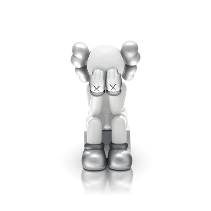 Veiled Thoughts - Electroplated by Landmark Decor features a gray and white cartoon figure with its head down, hands covering its face, and X marks on the hands—an artistic sculpture perfect for standout interior decor.