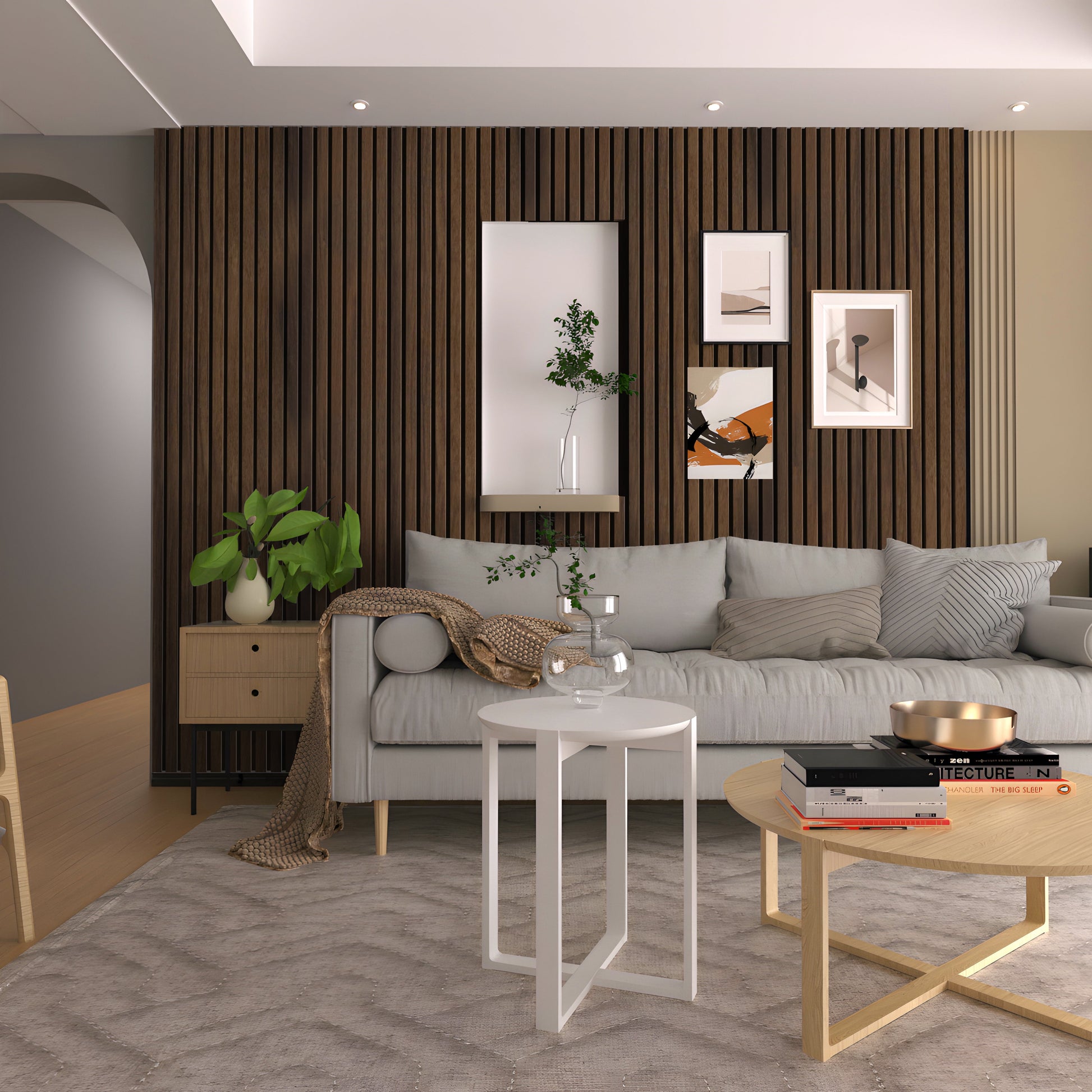 A modern living room featuring a gray sofa, Landmark Decor Dark Walnut Wood Texture WPC Fluted Slat Wall Panel as an accent wall, framed artwork, light tables, a potted plant, and neutral-toned decor.