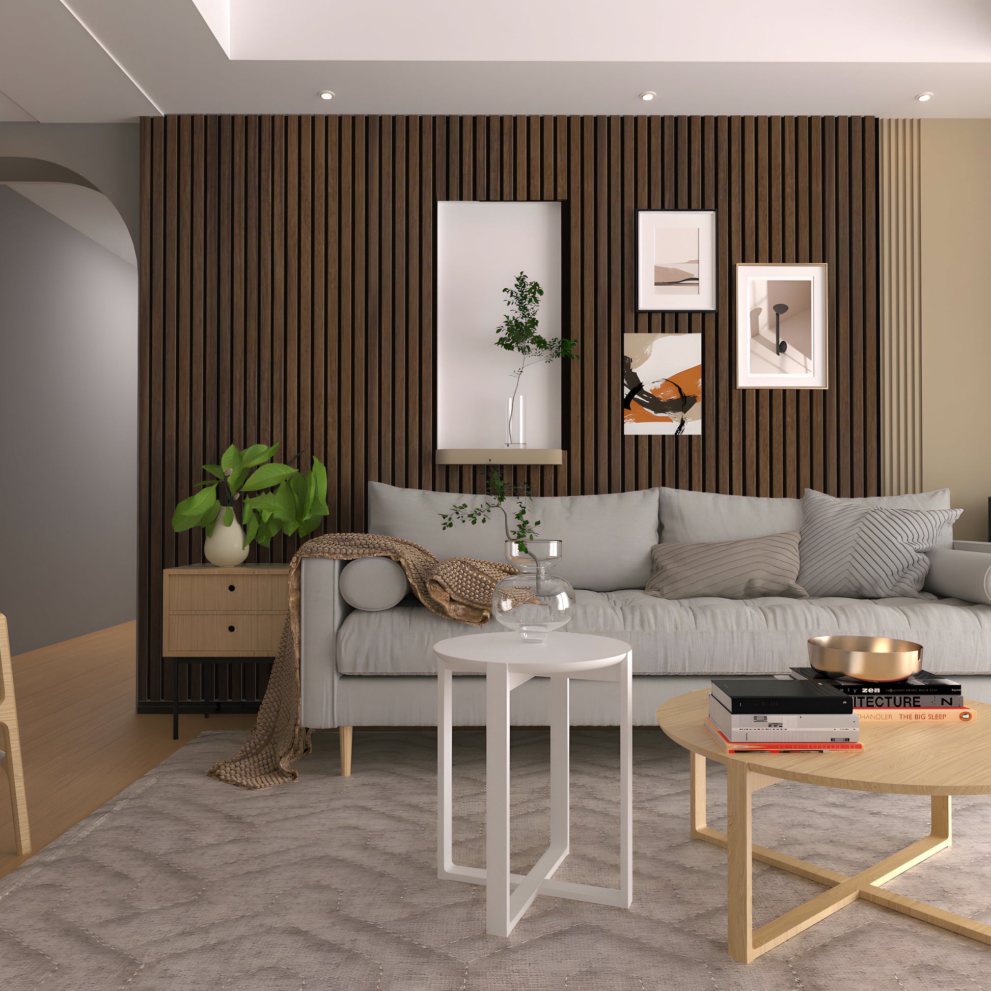 A modern living room features a gray sofa, framed artworks, round coffee tables, potted plants on a light rug, and a Landmark Decor Natural Walnut WPC Fluted Slat Wall Panel as an accent wall.