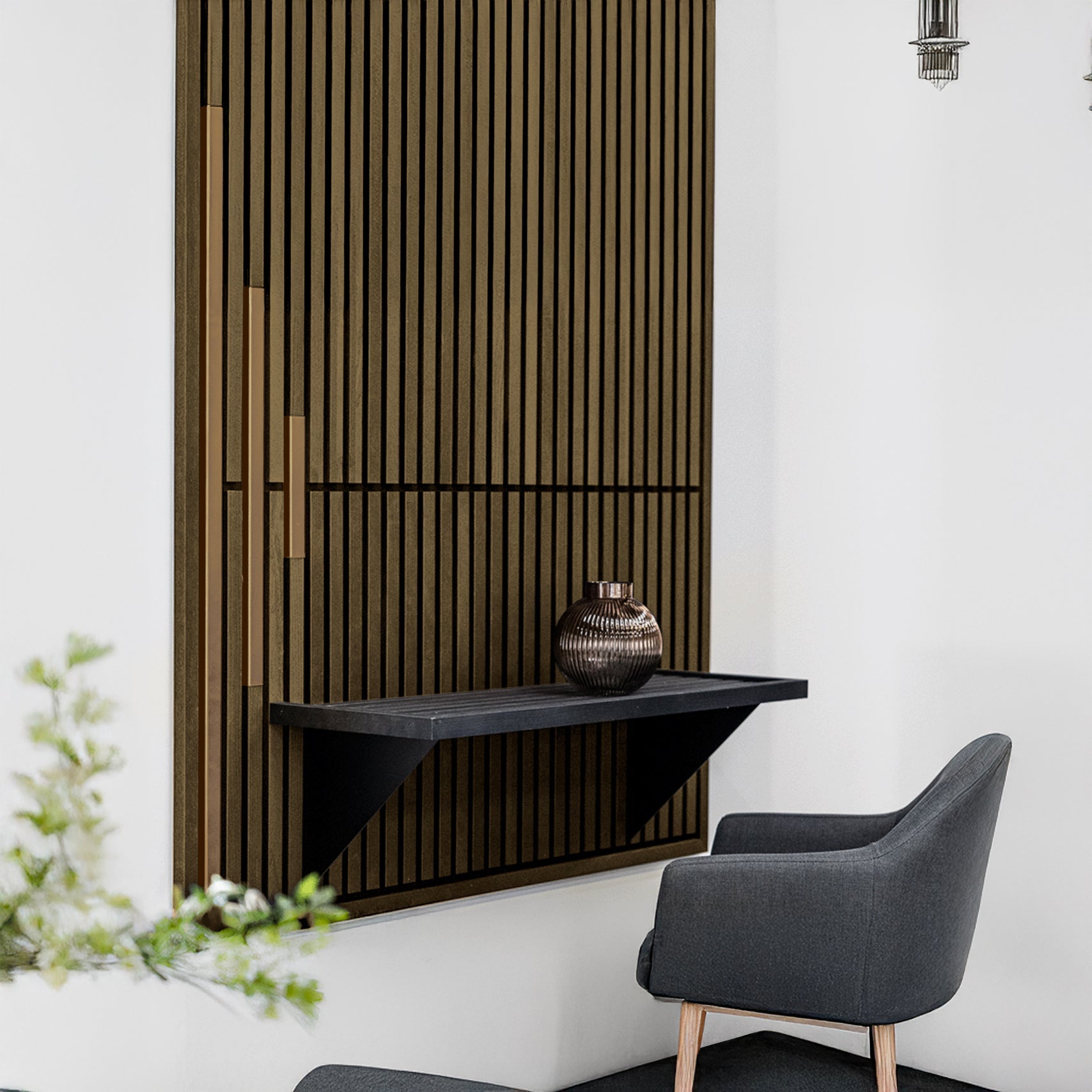 A modern interior featuring a gray armchair, a black floating shelf with a decorative vase, and Landmark Decor's Wood Panel Metal Cover-Bronze as vertical panels behind, creating striking visual patterns.